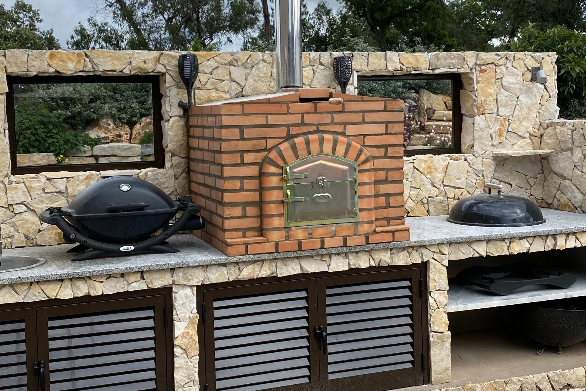 outdoor cooking area with bbq and pizza oven