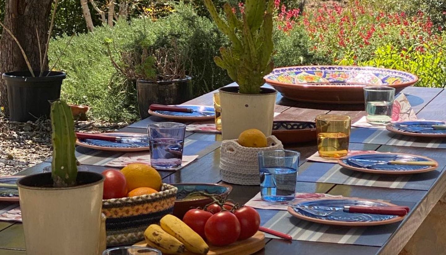 Outdoor dining table set in the garden for guests after a cooking experience at Figs on the Funcho in the Algarve countryside.